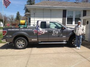 A D & H Pest Control truck with spraying equipment parked at a residential property for a pest control job in Erie, PA.