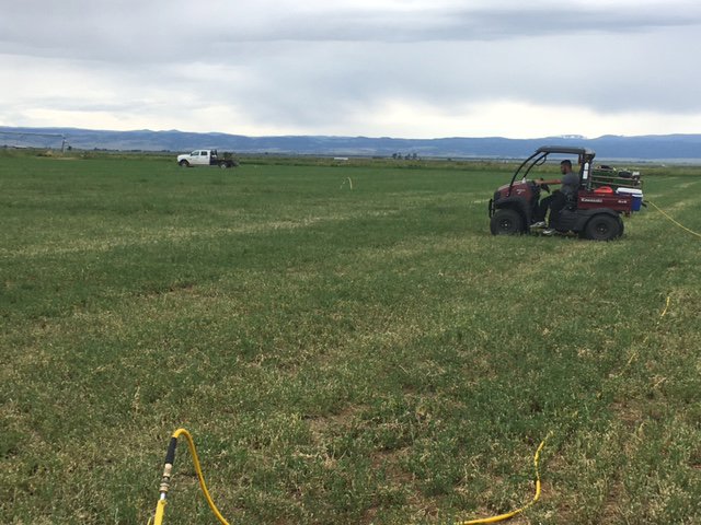 A pest control UTV with equipment being operated in a large field by No Moore Pests in Pueblo, CO.