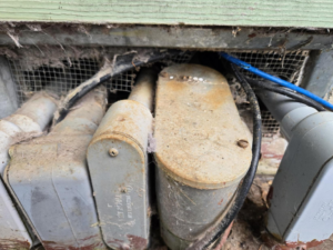A close-up of a building's exterior foundation showing a potential pest entry point during an inspection by Good Earth Pest Company in Corvallis, OR.