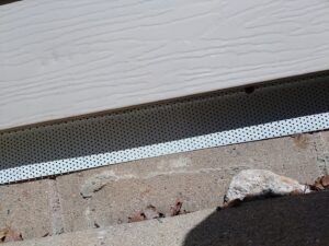 A perforated metal barrier installed along a house foundation for effective pest exclusion by Enviro-Pest Solutions in Waterloo, IA.