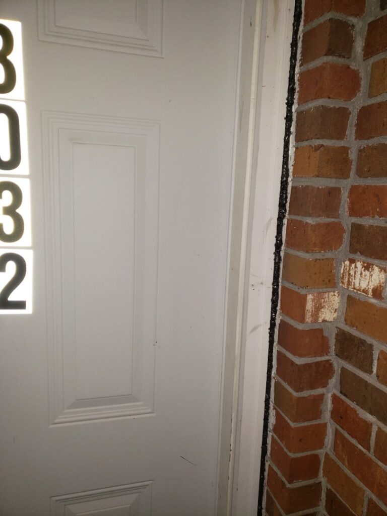 Close-up of a door frame and brick wall showing pest exclusion sealing by Absolute Exterminating Services in Ellenwood, GA.