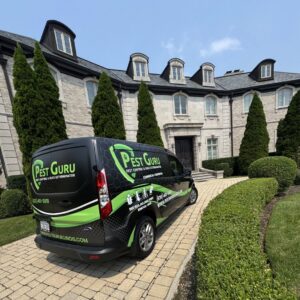 A Pest Guru Illinois branded van parked at a large residential property for a pest control job in Elgin, IL.