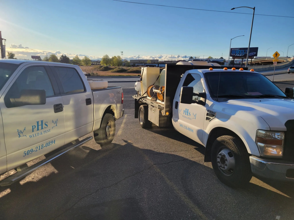 Two PHS Weed & Pest Control service trucks with spray equipment ready for jobs in Spokane, WA.