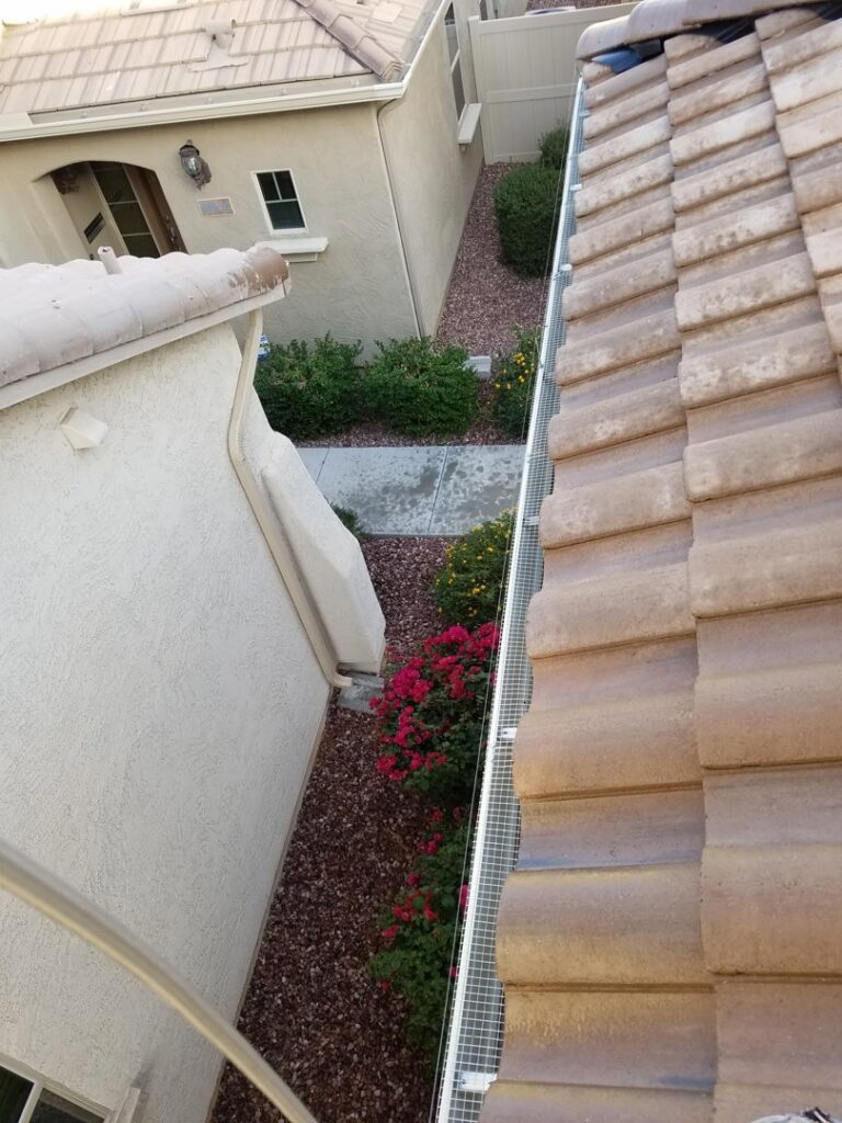A mesh barrier installed along a narrow side yard roofline for effective pigeon control by Pigeon Problem Solvers, LLC in Scottsdale, AZ.