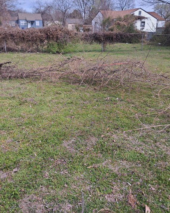 A large pile of cut branches and brush from a yard cleanup service by R & W Lawn care service LLC in Tulsa, OK.