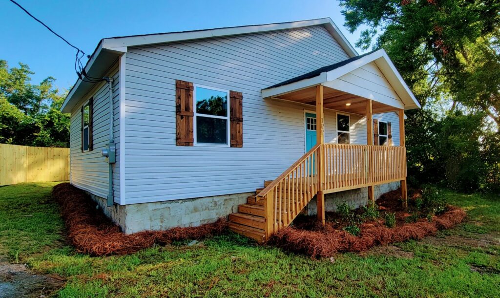 Fresh pine straw installed around the foundation of a new house, a landscaping service by Liberty LAWN Care in Sumter, SC.