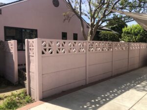 A unique pink concrete fence with decorative geometric cutouts installed by StackWall Manufacturing in Pomona, CA.