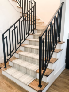 A wide view of a modern staircase featuring a plaid carpet runner expertly installed by Southern Star Finishes in Houston, TX.