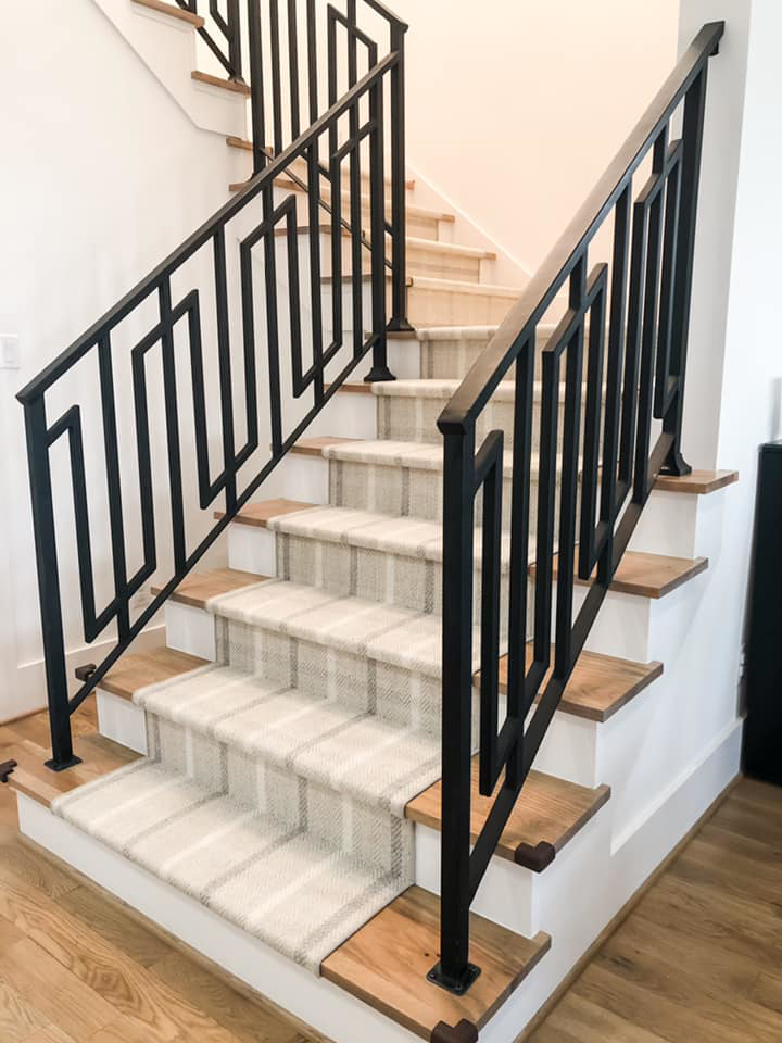 A wide view of a modern staircase featuring a plaid carpet runner expertly installed by Southern Star Finishes in Houston, TX.