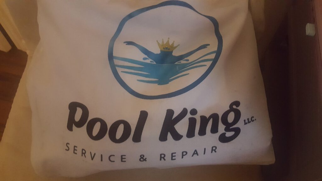 A professional pool cleaner at work, skimming a pool for Pool King in Southhold, NY.