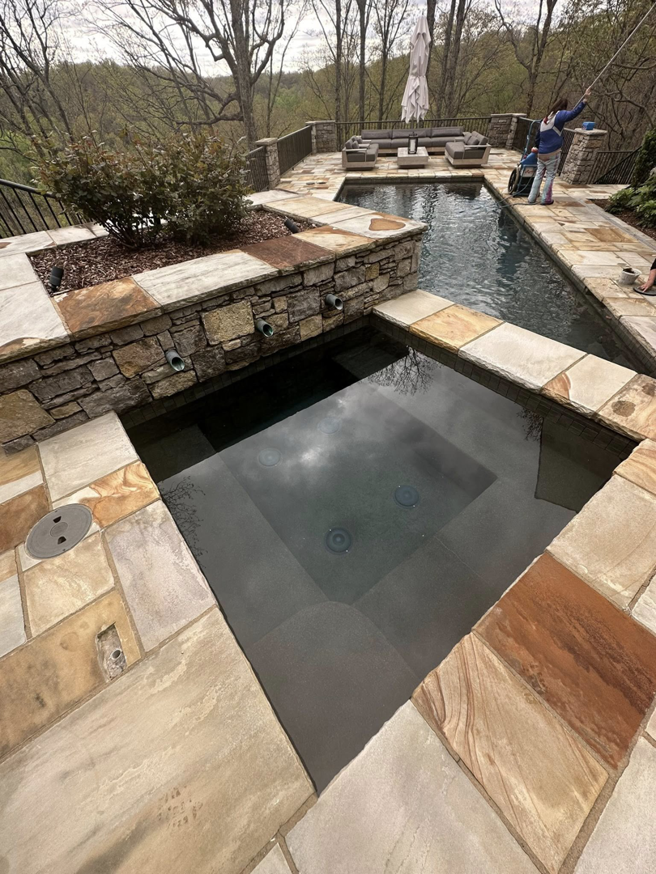 A pool cleaner brushing the edge of a swimming pool, providing service for Bluestone Pool Cleaning & Services in Clarksville, TN.