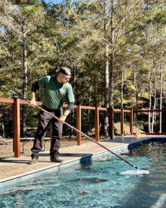 A pool cleaner from Freedom Pools removing debris from a residential swimming pool in Austin, TX.