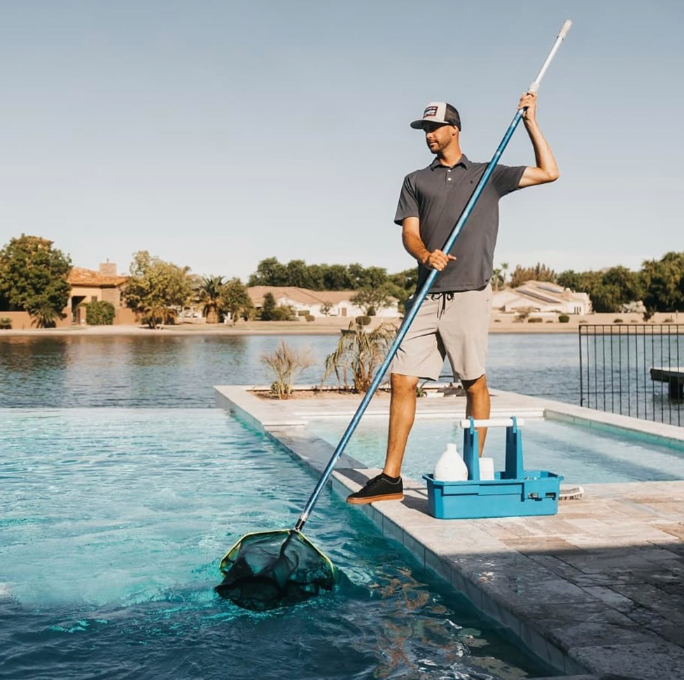 A pool cleaner actively skimming leaves and debris from a swimming pool for The Pool Service Pros in New Hill, NC.