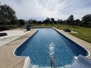 A pool cleaner from Gayle Force Pools vacuuming the bottom of a residential swimming pool in Lake Charles, LA