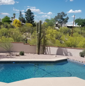 A pool cleaning service in progress with a hose by Up Keep Pool & Spas in Tucson, AZ.