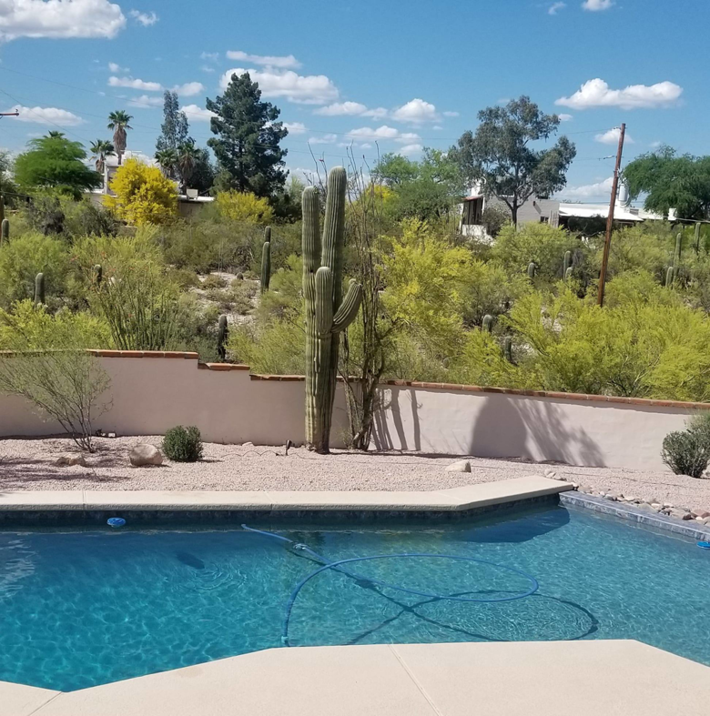 A pool cleaning service in progress with a hose by Up Keep Pool & Spas in Tucson, AZ.