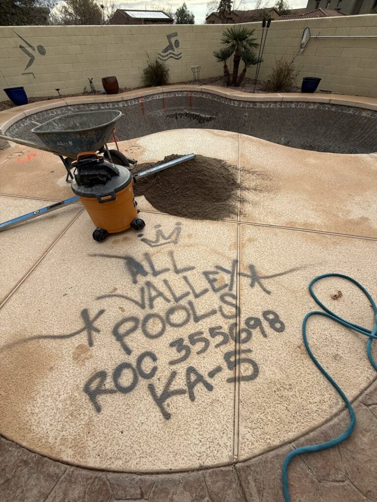 An empty pool under construction with tools and 'All Valley Pools' marked on the deck in Avondale, AZ.