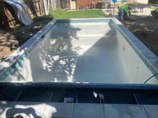A pool under construction with a worker in the background, demonstrating the work of Wetworks Pool and Spa in Englewood, CO.