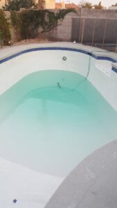 A swimming pool being drained or filled, showcasing the interior finish by Blue Magic Pools and More Inc. in Gilbert, AZ.