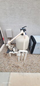 Pool filtration and pump equipment located next to a house, representing maintenance services by Edward's Pool Service, LLC in Gilbert, AZ.