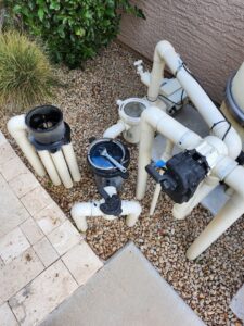 Pool equipment being serviced with a wrench by Blue Square Manufacturing, LLC, providing expert pool cleaner services in Chandler, AZ.