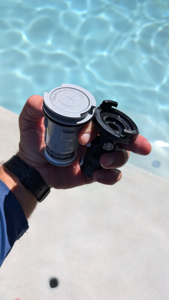 A hand holding pool equipment repair parts for service by Parkinson Pools in Peoria, AZ