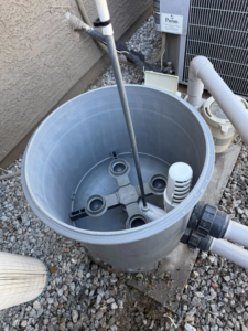 An open pool filter housing with a dirty filter cartridge removed for cleaning or replacement by Big Foot Pool Care in Buckeye, AZ