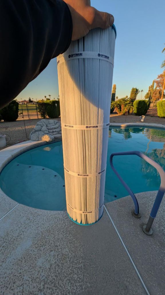 A large pool filter cartridge being held for replacement or cleaning by Parkinson Pools in Peoria, AZ