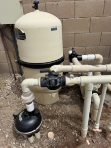A large pool filter system with pipes and valves, indicating maintenance services by Big Foot Pool Care in Buckeye, AZ