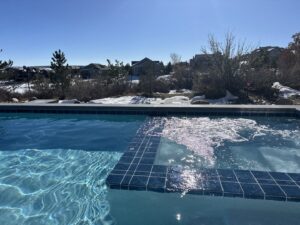 A beautiful pool with an integrated bubbling spa, a completed project by Wetworks Pool and Spa in Englewood, CO.