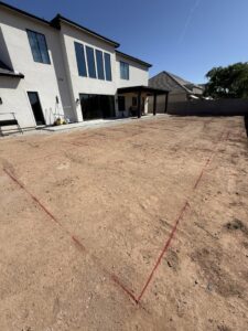 A new swimming pool layout marked with red lines on the ground, ready for excavation by All Valley Pools in Avondale, AZ.