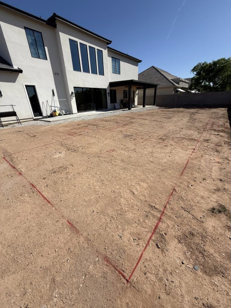 A new swimming pool layout marked with red lines on the ground, ready for excavation by All Valley Pools in Avondale, AZ.