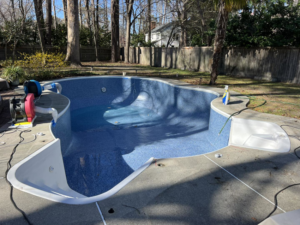Pool maintenance equipment next to an empty pool with a new liner by Pipeline Pools Inc. in Virginia Beach, VA.