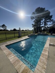 A pool maintenance technician from Gayle Force Pools working on a pool feature by the water's edge in Lake Charles, LA