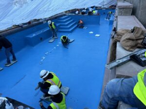 Pool contractors applying plaster during a new pool installation by Wetworks Pool and Spa in Englewood, CO.