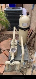 Close-up of pool pump and filter equipment, representing the technical aspects of pool cleaning and maintenance by Space Ranger Pools in Gilbert, AZ.