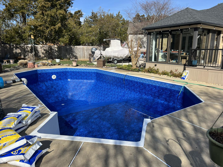 Pool renovation in progress with chemical bags on the deck by Pipeline Pools Inc. in Virginia Beach, VA.