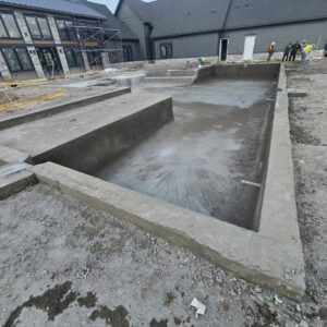 The concrete shell of a new pool under construction, showing steps and benches, by EZ POOL Solutions in Tucson, AZ