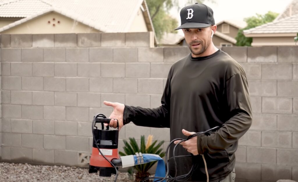 A pool technician holding a drain pump and hose, performing a service for Pool Rescuers LLC in Gilbert, AZ.