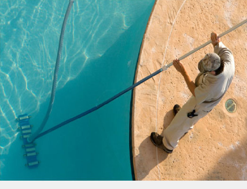 A pool technician vacuuming a residential swimming pool as part of Aqua Doc Pool And Spa services in Franklin, TN.
