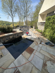 A pool technician working inside an empty pool, performing maintenance for Bluestone Pool Cleaning & Services in Clarksville, TN.