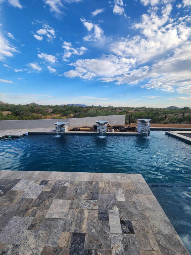 A completed pool showcasing modern water features and desert landscaping by EZ POOL Solutions in Tucson, AZ