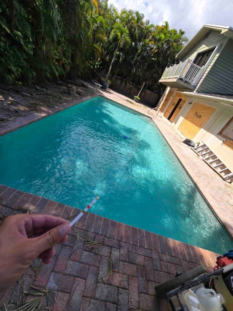A pool technician performing a water quality test with a strip for Summer Breeze Pool Services in Fayetteville, GA.