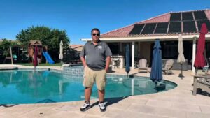 A pool with a floating cleaner and hose actively working, demonstrating pool cleaning by E and E Pools in Chandler, AZ.