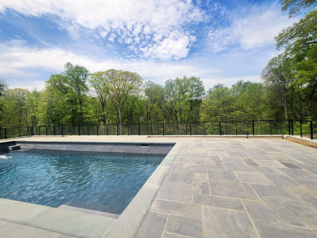 A modern cable railing fence installed around a swimming pool area by H&M Fence, LLC in Norwalk, CT.