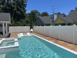 Modern white and tan horizontal slat fences surrounding a pool area, installed by Fence Nation LLC in Jacksonville, FL.