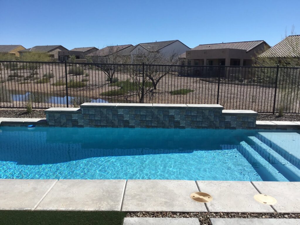 A poolside metal snake fence with a block wall, providing safety and protection, installed by Arizona Snake Fence LLC in Tucson, AZ