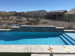 A poolside metal snake fence with a block wall, providing safety and protection, installed by Arizona Snake Fence LLC in Tucson, AZ