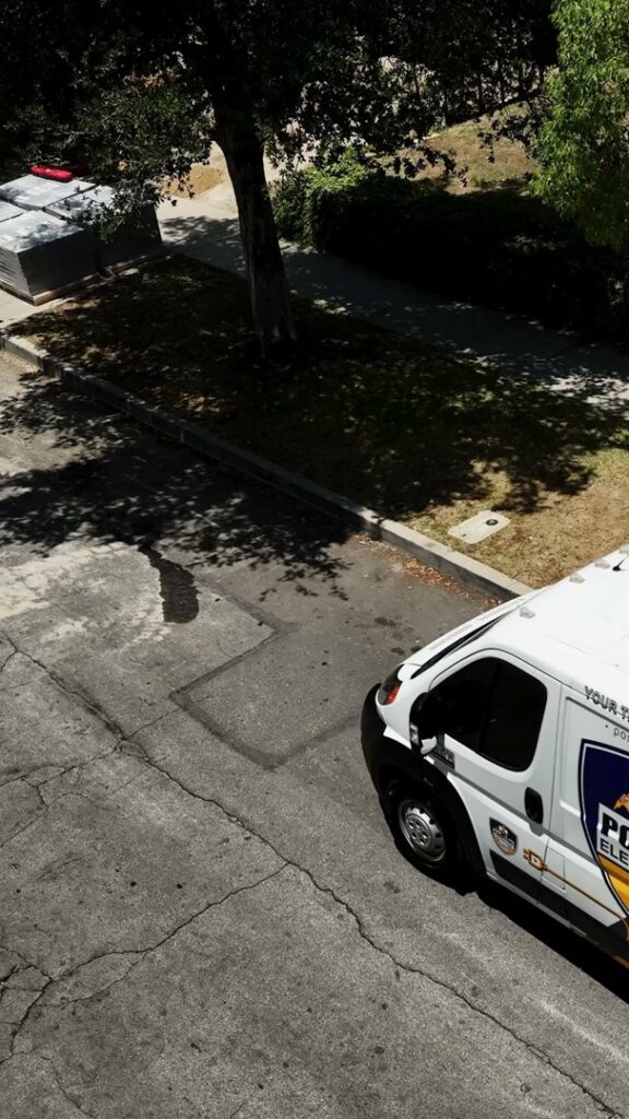 A Positive Electricians service van parked on a street in Van Nuys, CA, ready for a job.