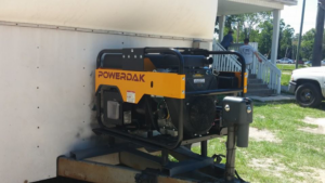 A POWERDAK generator mounted on a trailer, indicating services provided by Dave Capps Electric Service in Panama City, FL.